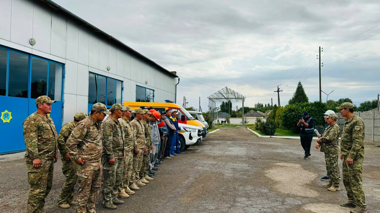 Әскери формадағы сарбаздар мен құтқарушылардың желтіргіш көліктер жанындағы жиыны.