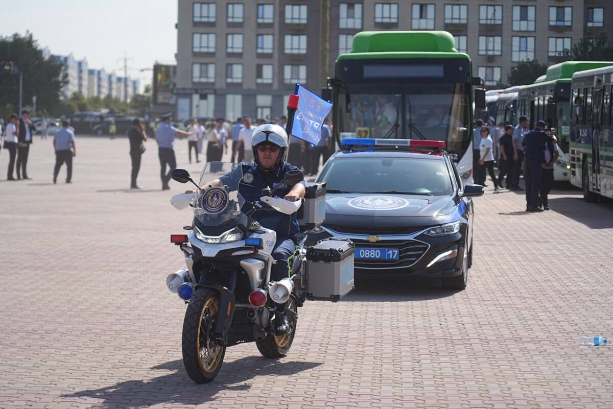 Мотоциклмен және автокөлікпен жүрген полиция қызметкерлері.