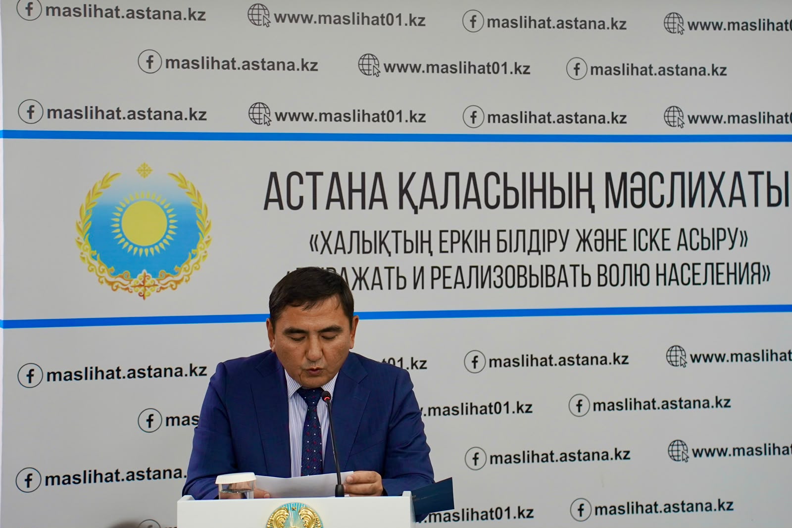 Астана қаласының мәслихатының алдында сөйлеп тұрған ер адам.