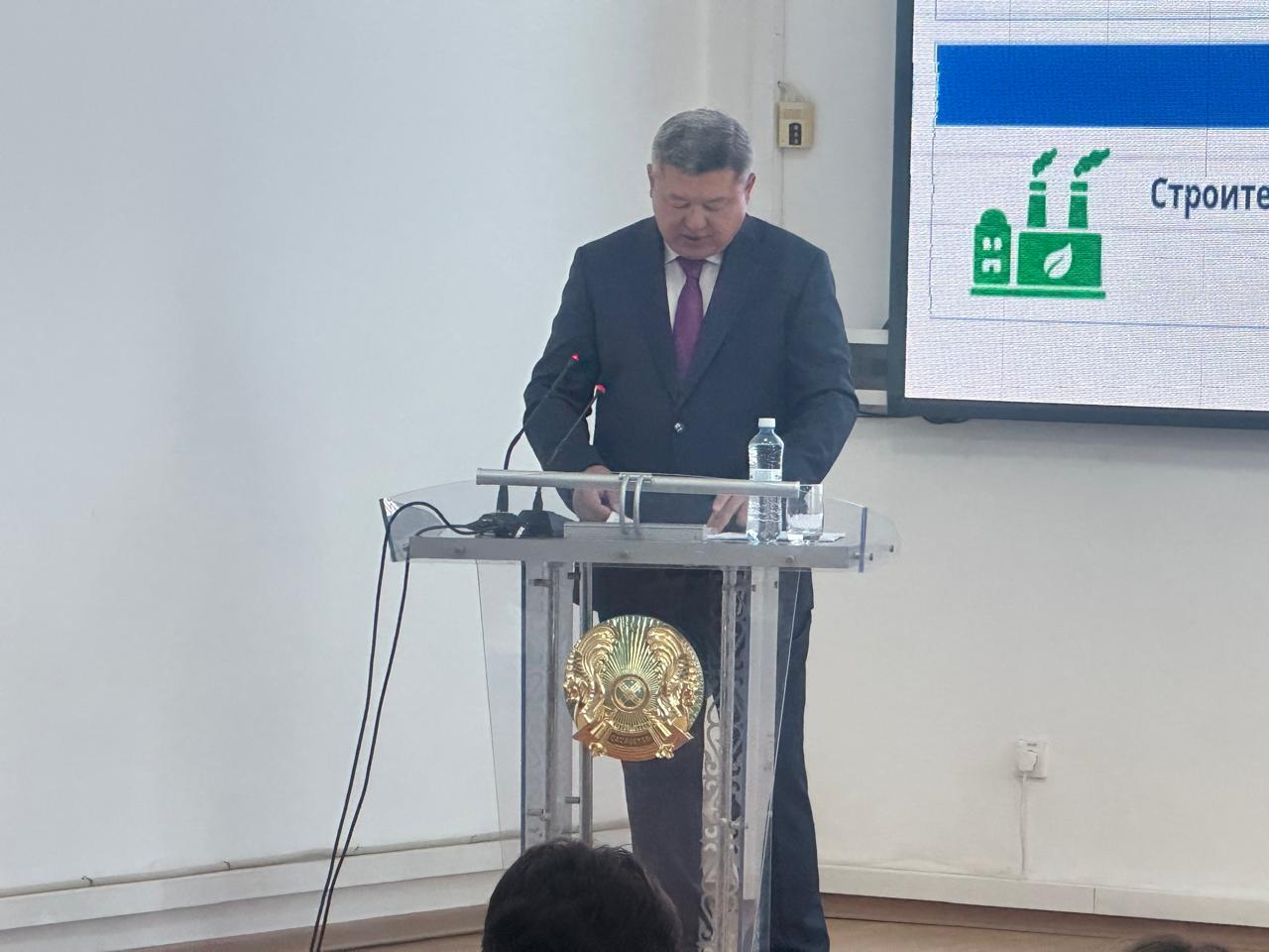 Костюм киген ер адам трибунада сөйлеп тұр.