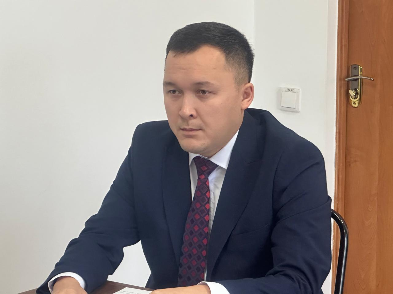 Көк костюм мен қызыл галстук киген ер адамның портреті.
