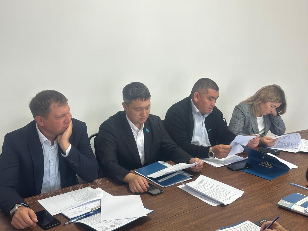 Келіссөз жүргізіп жатқан төрт адамның жұмыс үстеліндегі суреті.