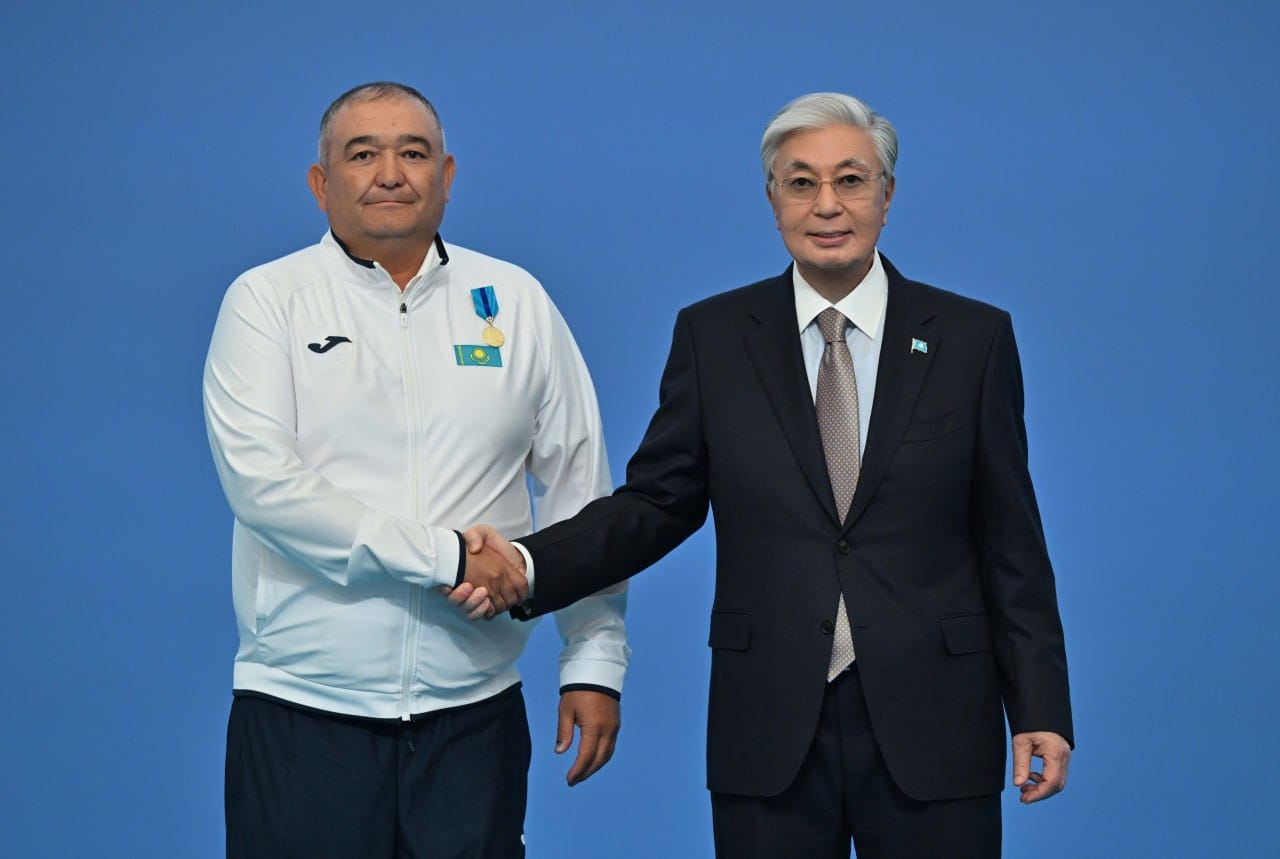 Қазақстан Президенті Қ.Тоқаев пен спортшының қол алысуы.