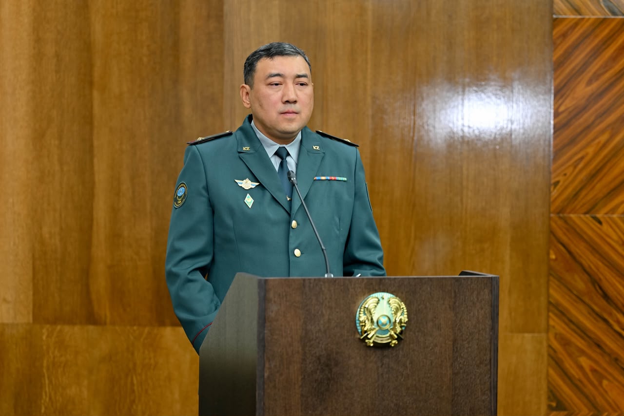 Әскери формадағы ер адам трибунада сөйлеп тұр.