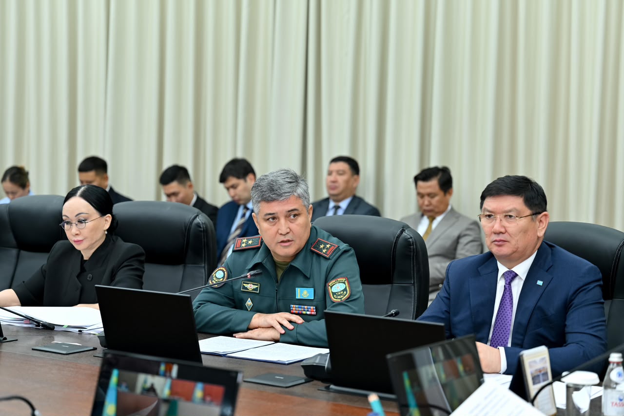 Жиналыста отырған әскери формадағы және костюм киген ресми тұлғалар.