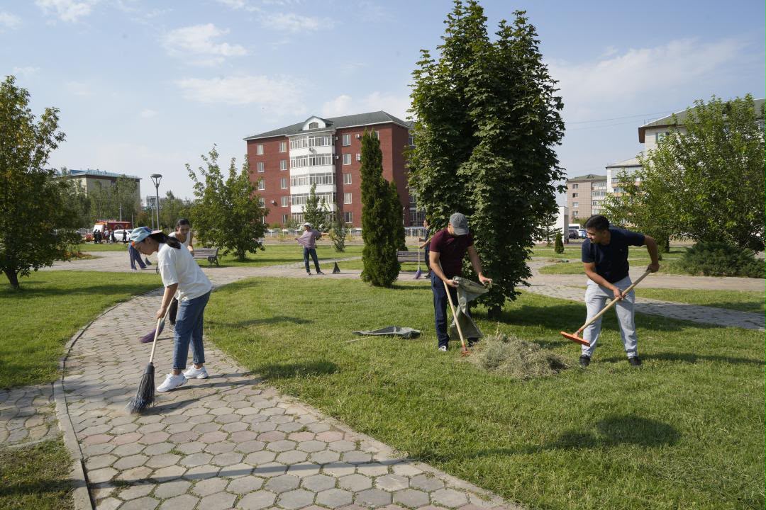Парктегі аллея мен жасыл аймақты тазалап жатқан жастар.