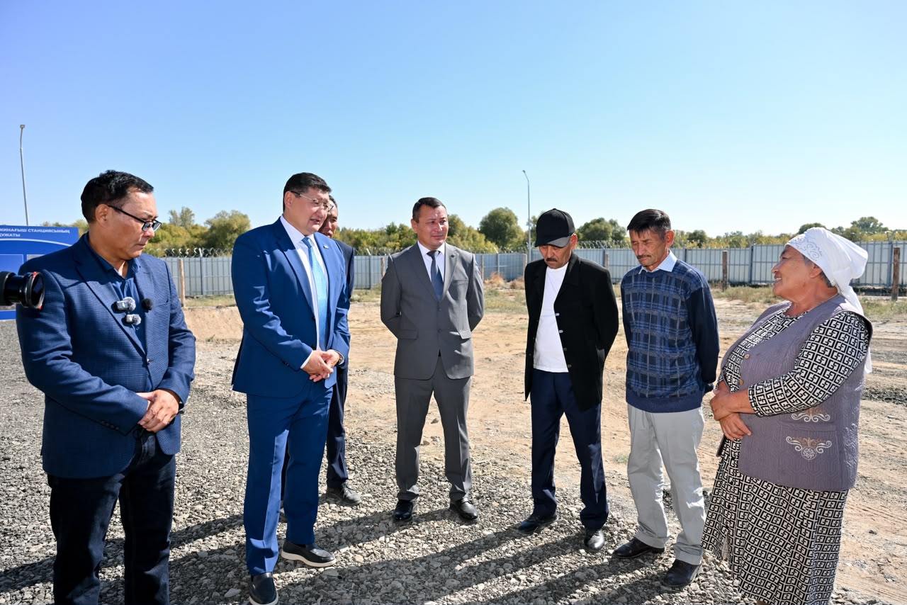 Костюм киген ресми тұлғалар мен жергілікті тұрғындардың ашық аспан астындағы кездесуі.