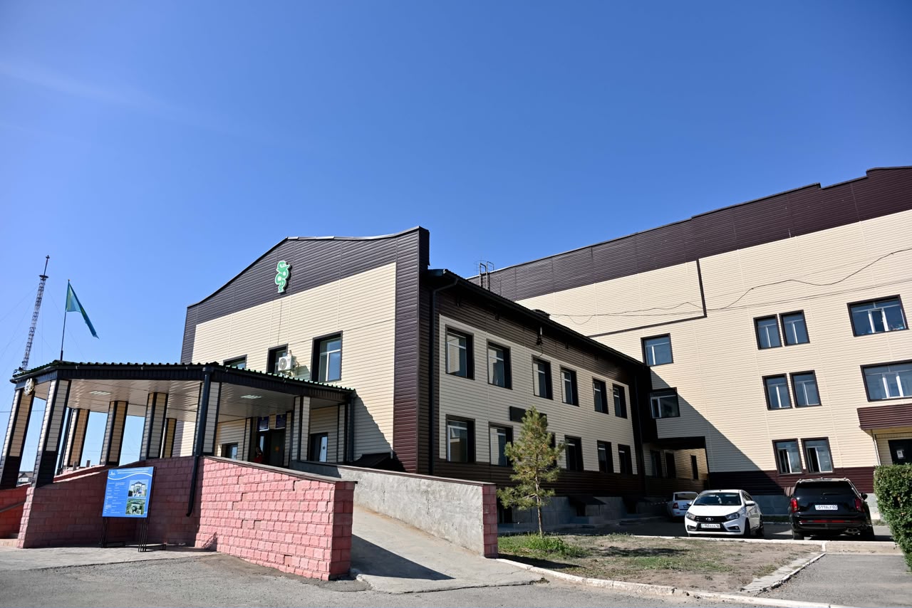 Күн шуақты күндерігі екі қабатты заманауи әкімшілік ғимараттың сыртқы көрінісі.