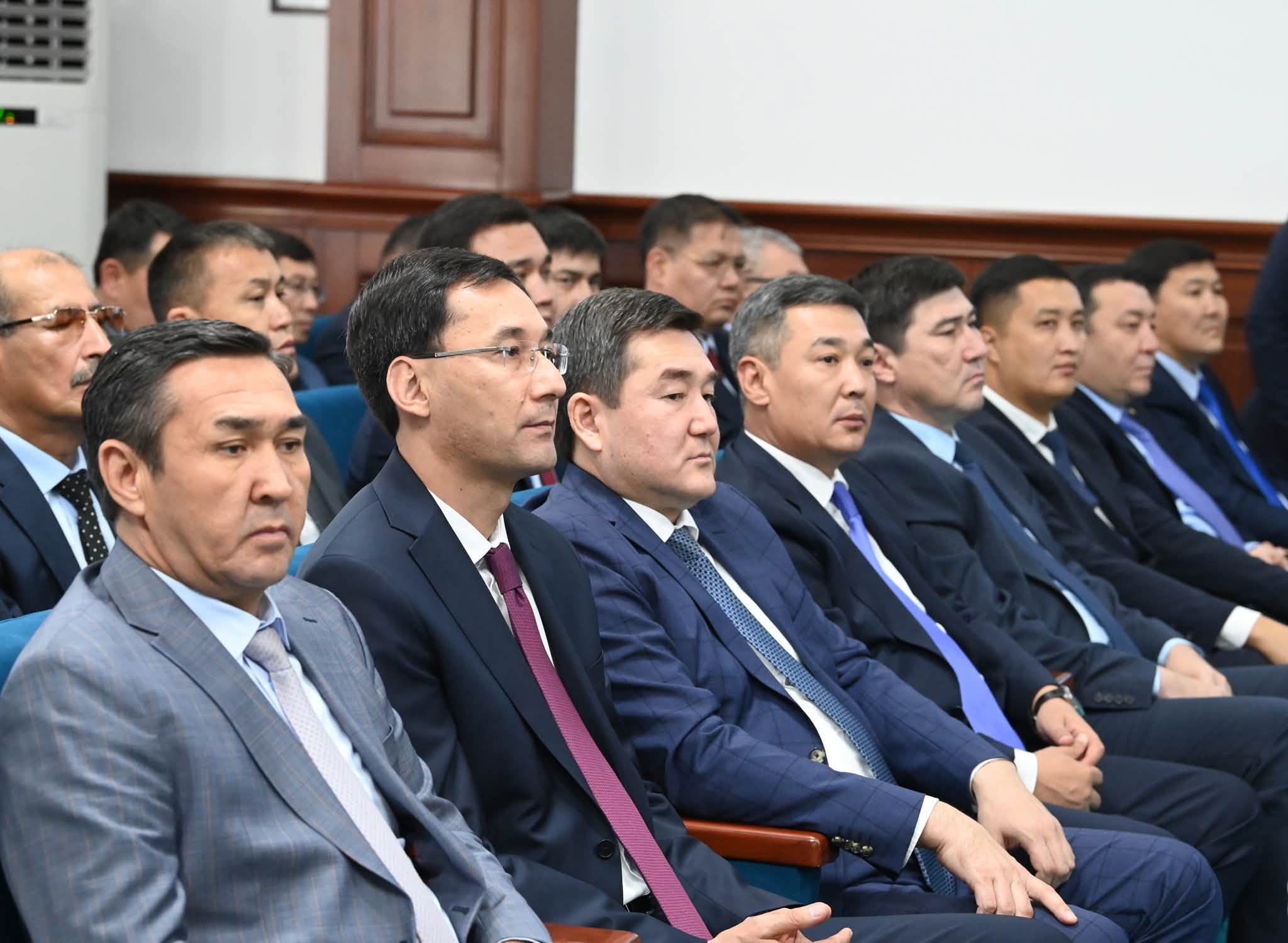 Костюм киген ер адамдардың жиналыста отырған сәті.