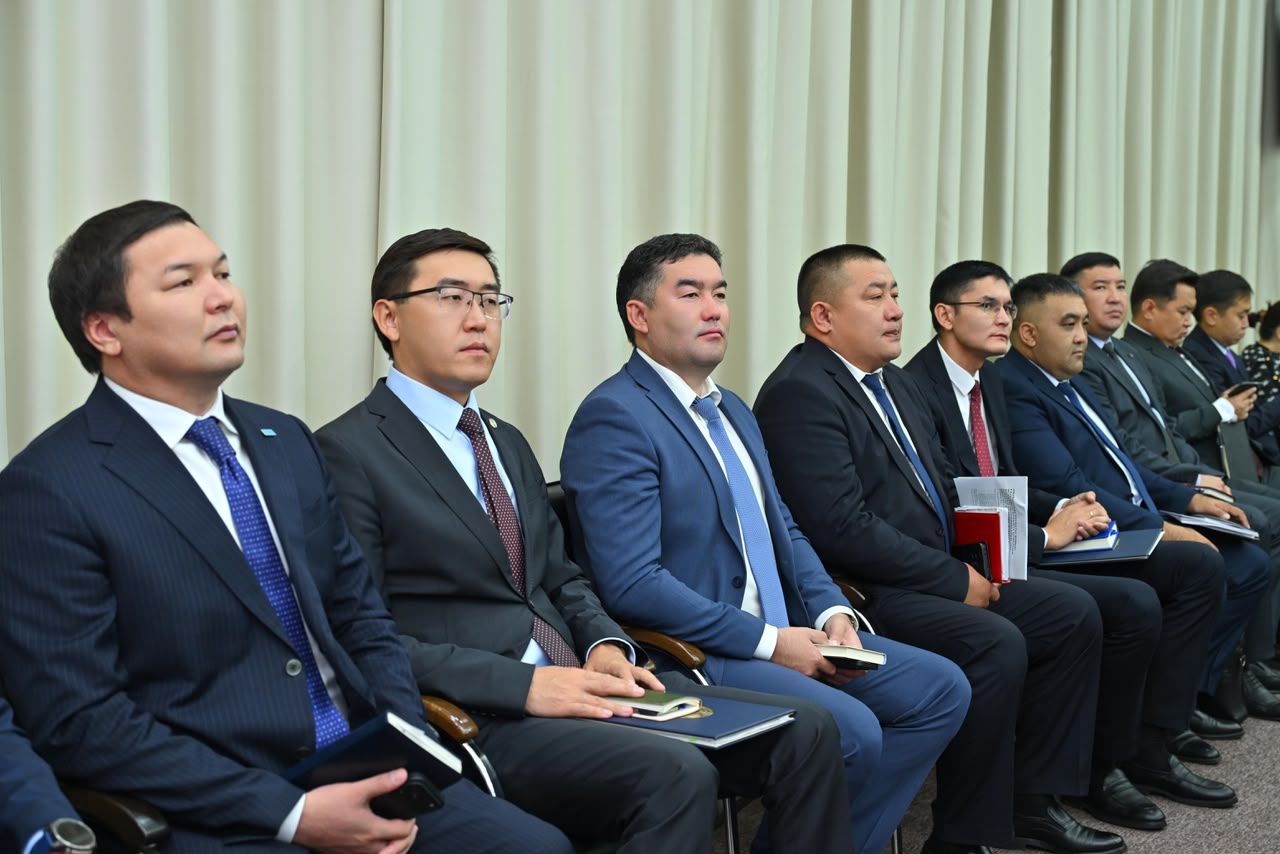 Костюм киген ер адамдардың жиналыста отырған сәті.