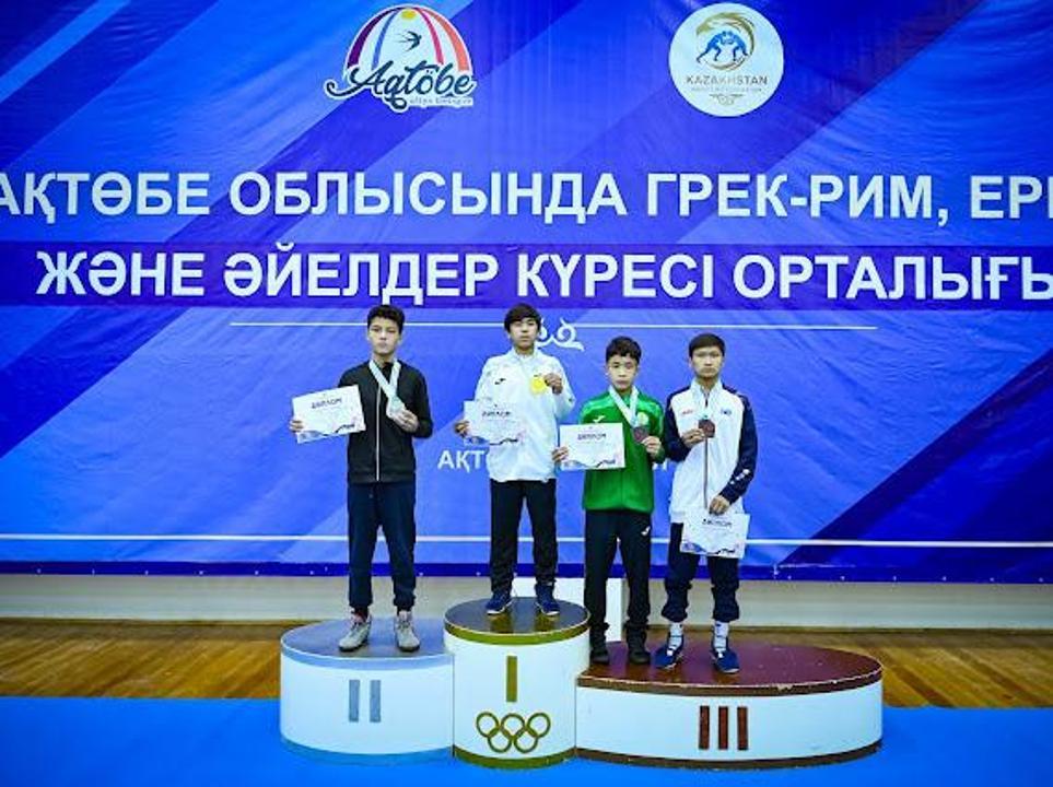 Күрес жарысының жеңімпаздары сыйлықтарды алып, пьедесталда тұр.