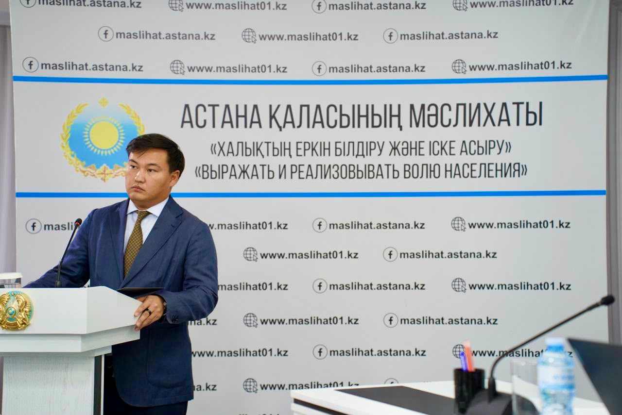 Астана қаласының мәслихатының алдында сөйлеп тұрған ер адам.