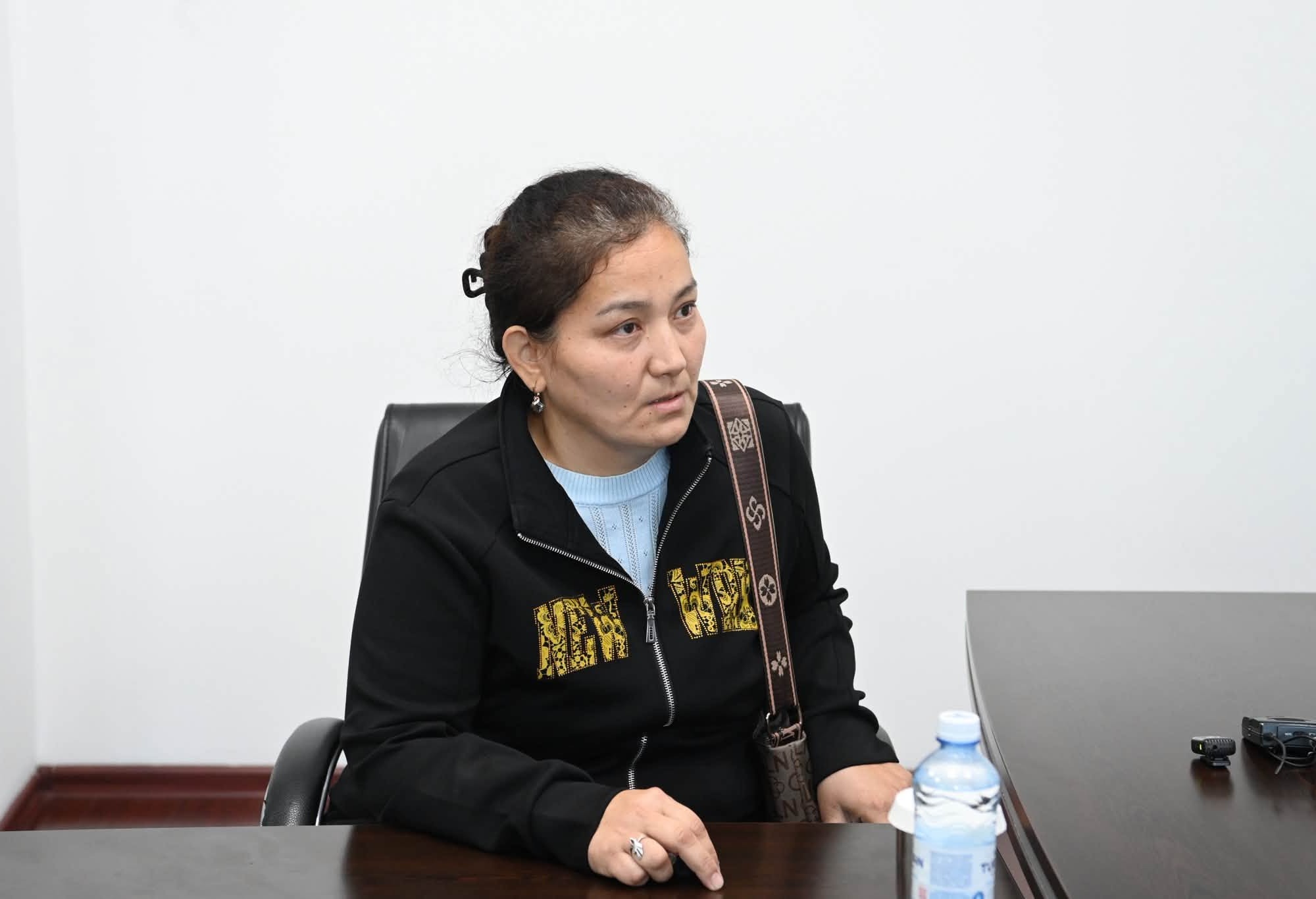 Қабылдауда отырған қара жакет киген әйел.