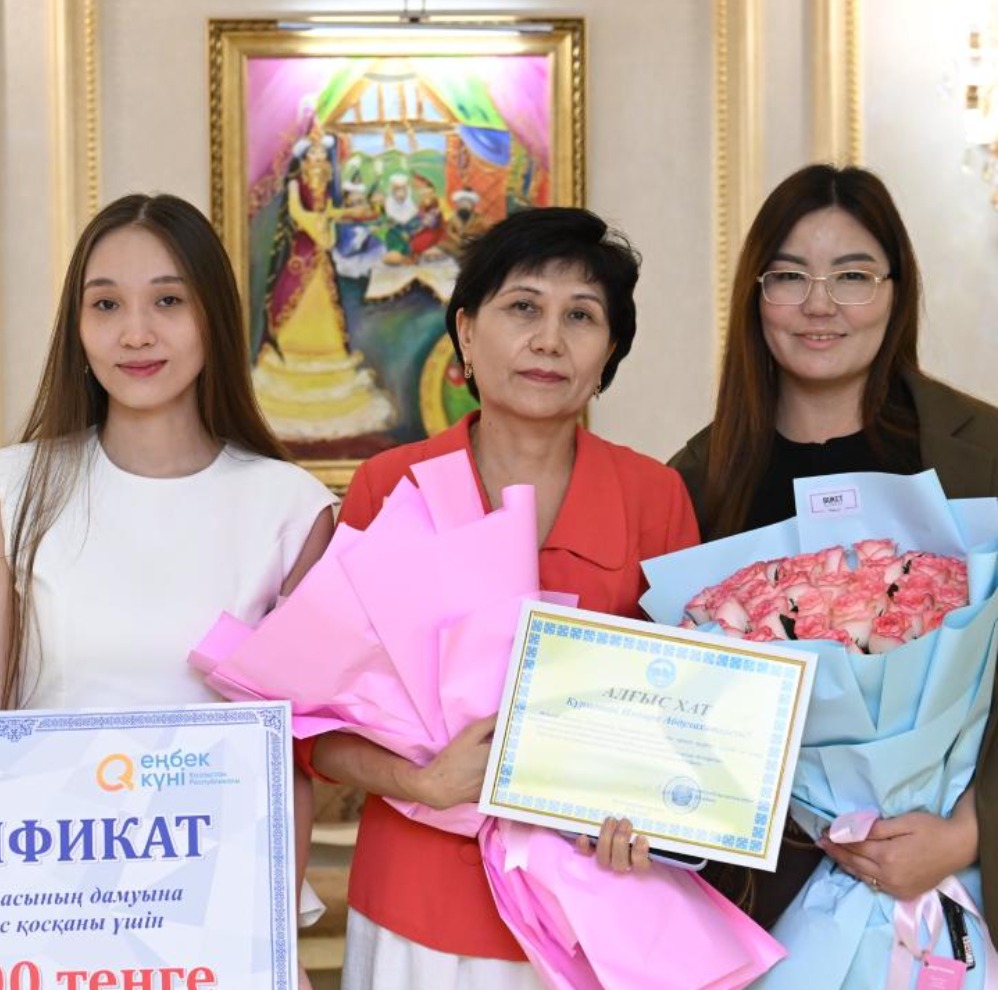 Гүлдер мен алғыс хат ұстаған әйел адамдар.