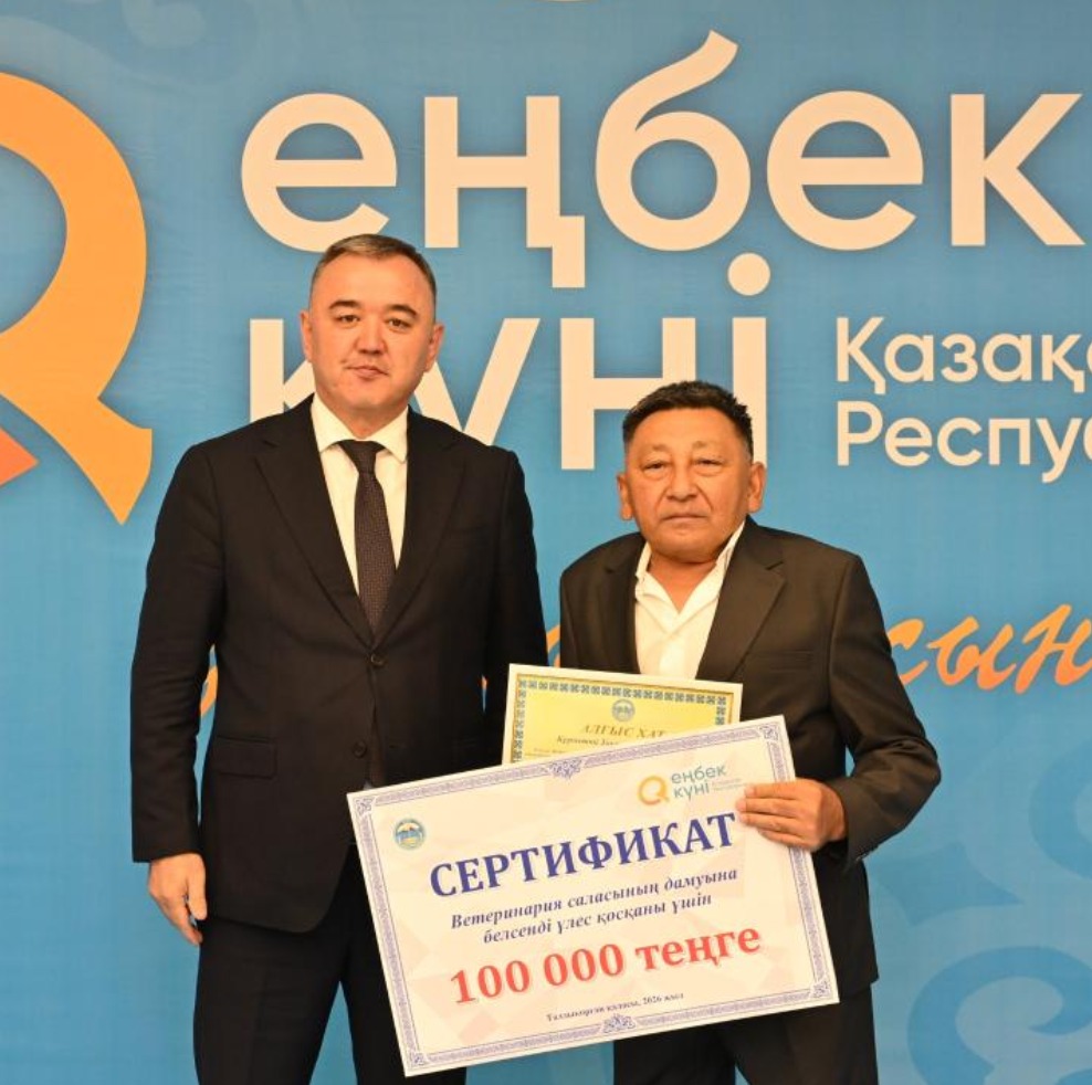 Еңбек күні қарсаңында сертификат пен алғыс хатты табыстап жатқан екі ер адам.