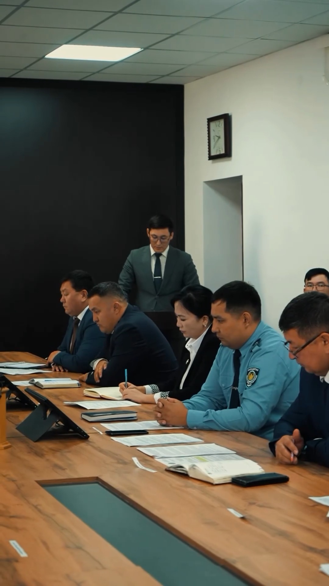 Жылынамада жиналып отырған ресми киімдегі адамдар тобы.