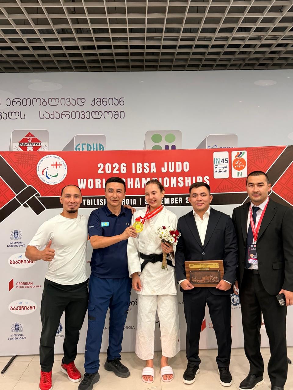 2026 жылғы IBSA дзюдо әлем чемпионатында алтын медаль алған спортшы мен жаттықтырушылардың Тбилисидегі суреті.
