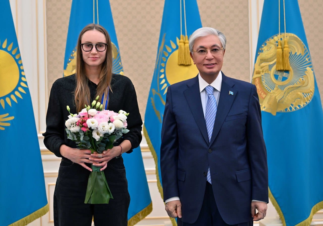 Қазақстан Республикасының Президенті Қасым-Жомарт Тоқаев пен гүл ұстаған бойжеткеннің суреті.