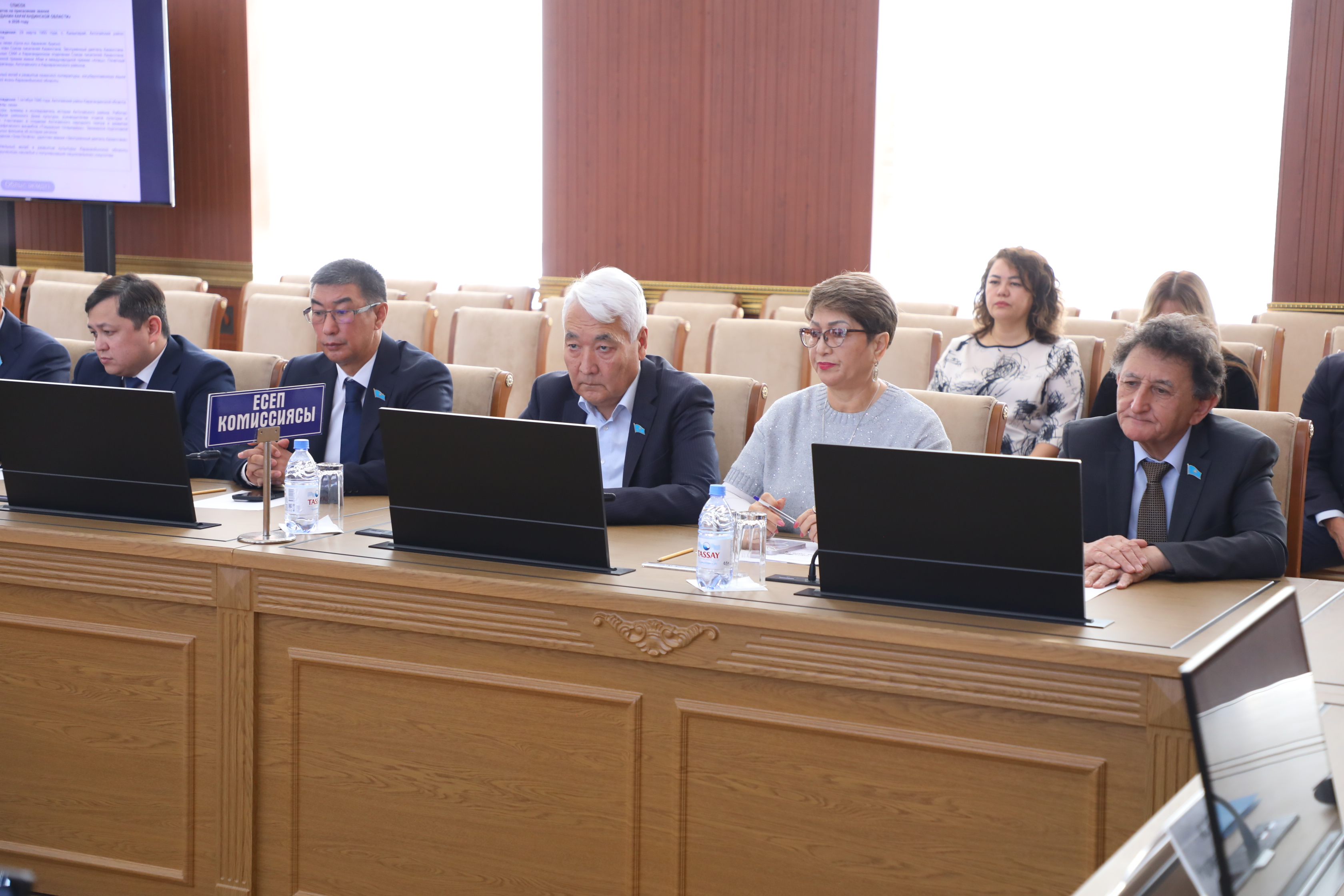 Жиналыста ноутбуктермен жұмыс істеп отырған комиссия мүшелері.