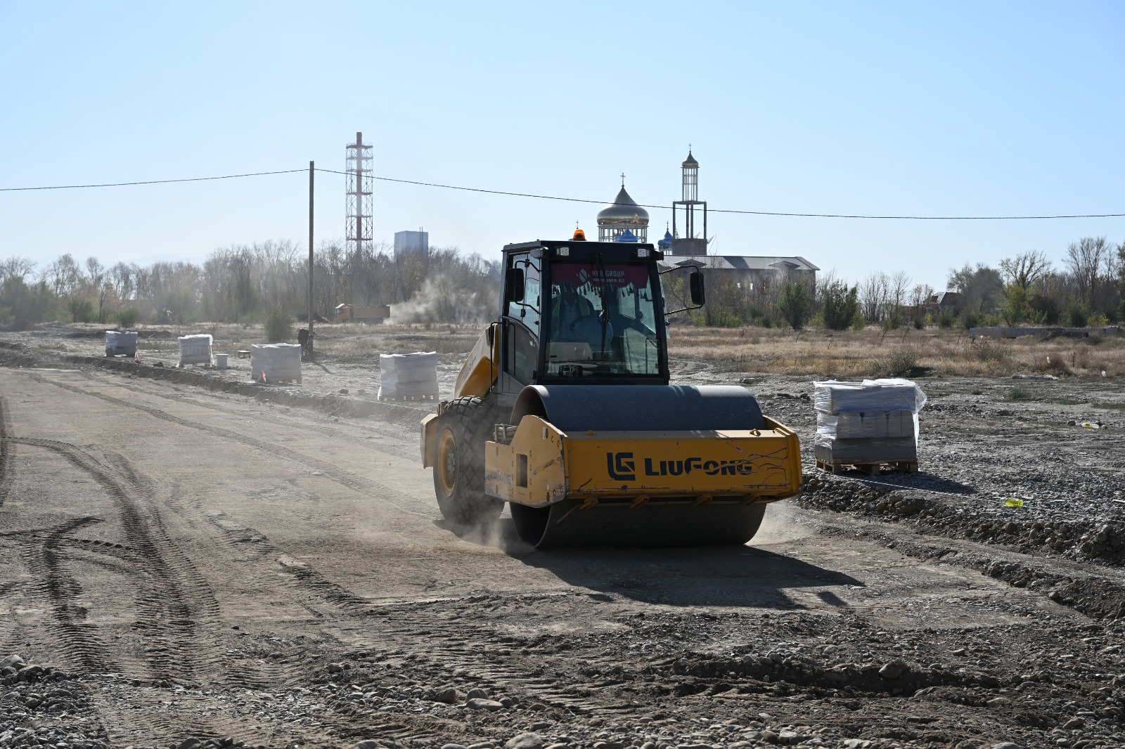 Жол құрылысында жұмыс істеп жатқан сары түсті LiuGong жол салғыш роллы.