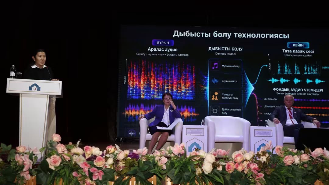 Сахнадағы спикерлер мен «Дыбысты бөлу технологиясы» туралы презентация экраны.