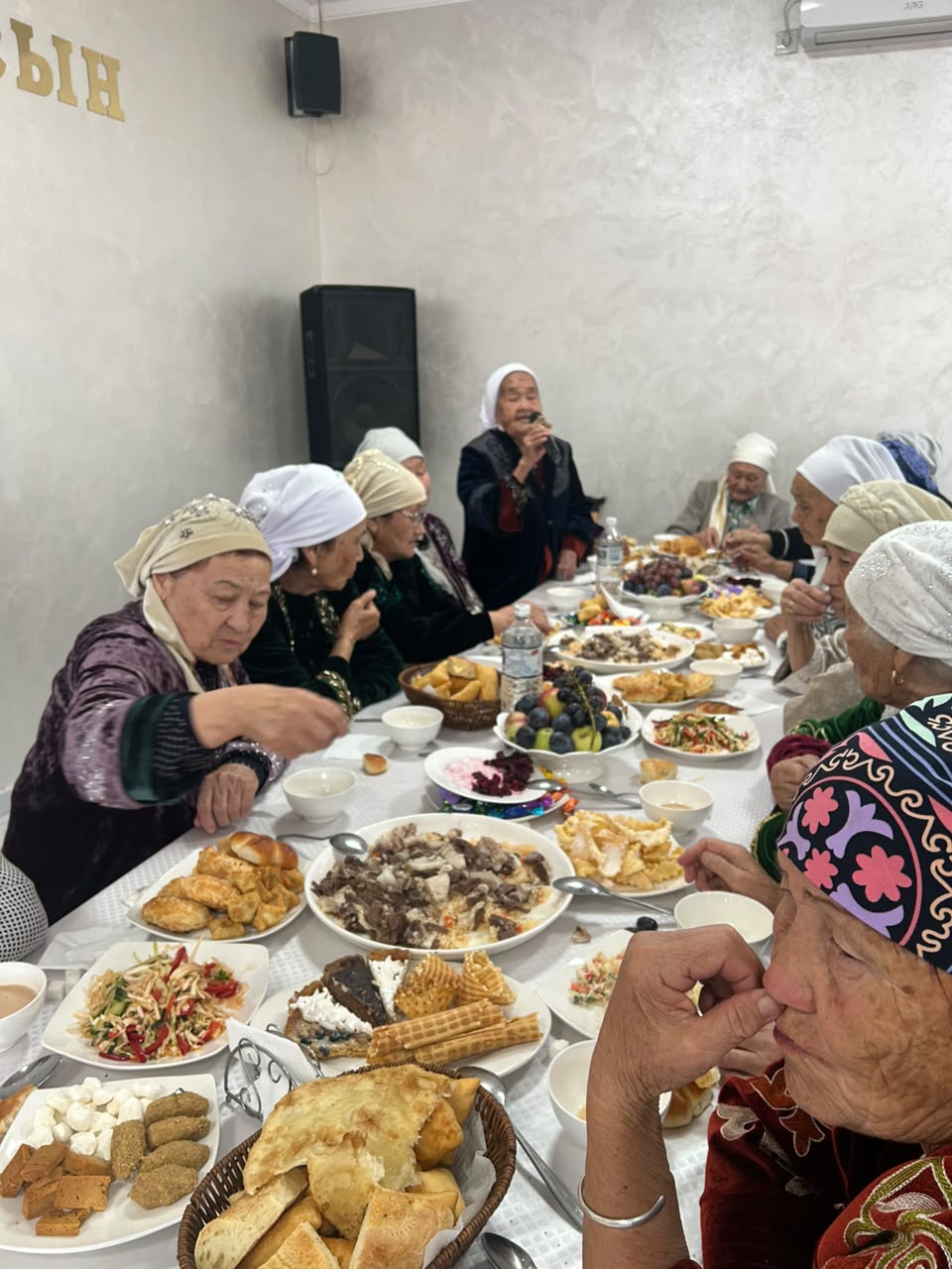 Ұлттық киім киген әжелер ас ішіп отырғаны.