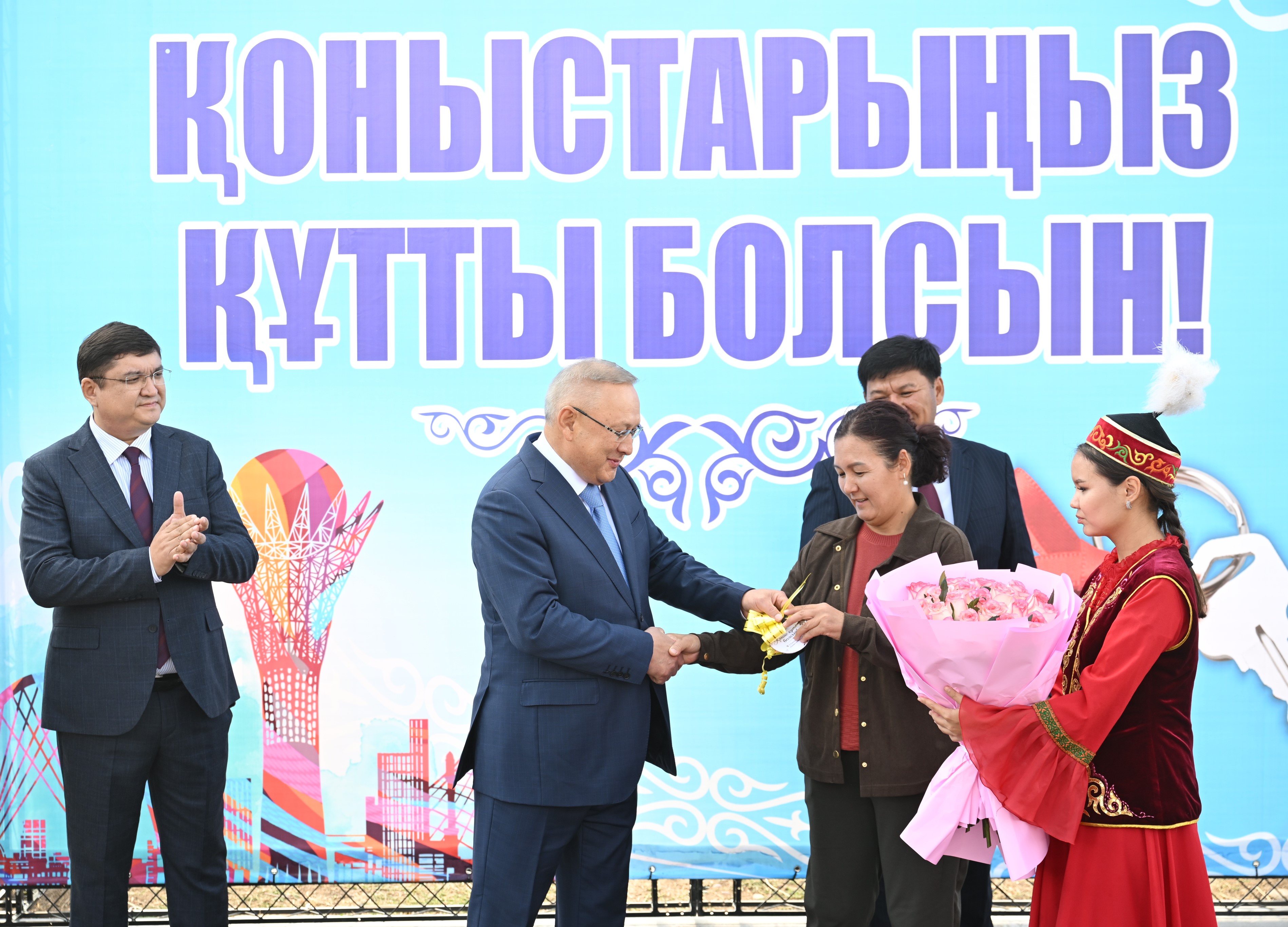 Бейбит Исабаев вручает новоселам ключи от нового жилья.