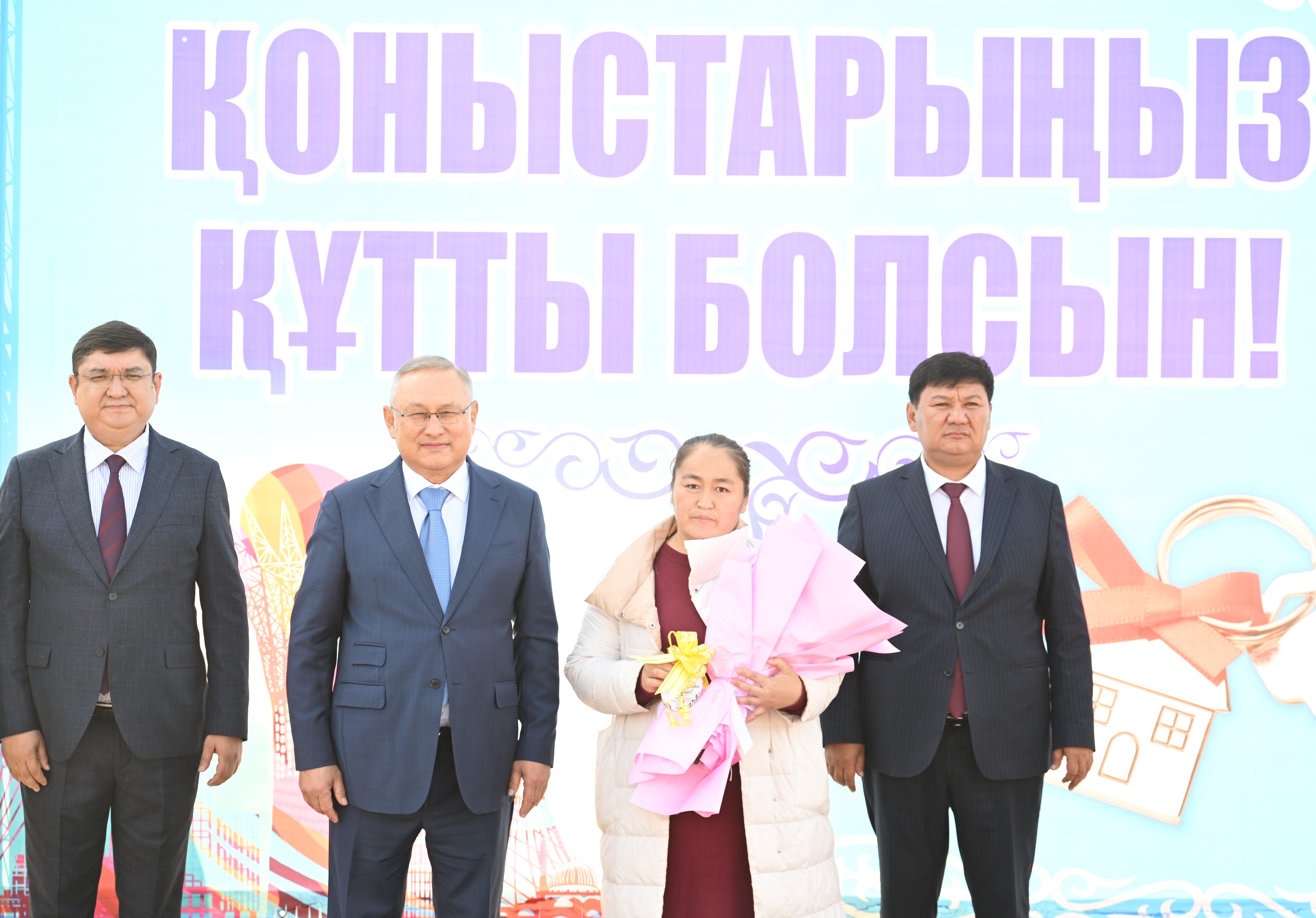 Бейбит Исабаев вручает новоселам ключи от нового жилья.