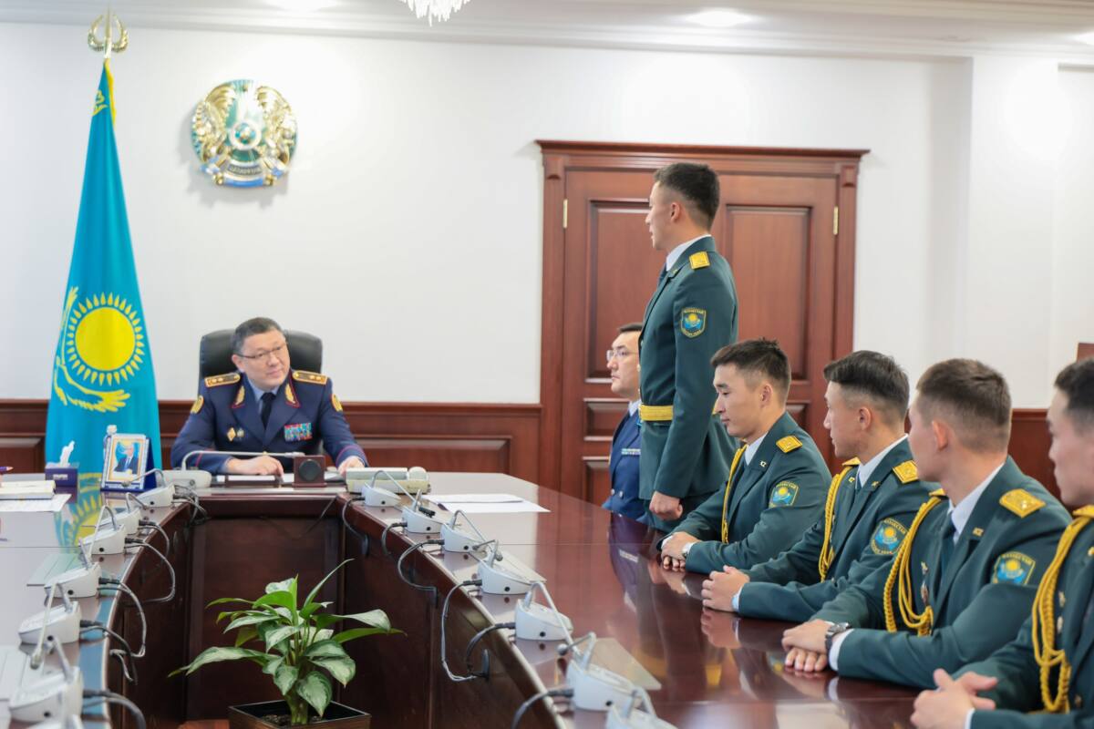 Әскери формадағы офицерлердің министр Ержан Саденовпен жиналысы. Үстел басында Қазақстан Республикасының Туы мен Елтаңбасы тұр.