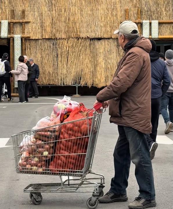 Көлік арбасына толы көкөністерді сүйреп бара жатқан қария.