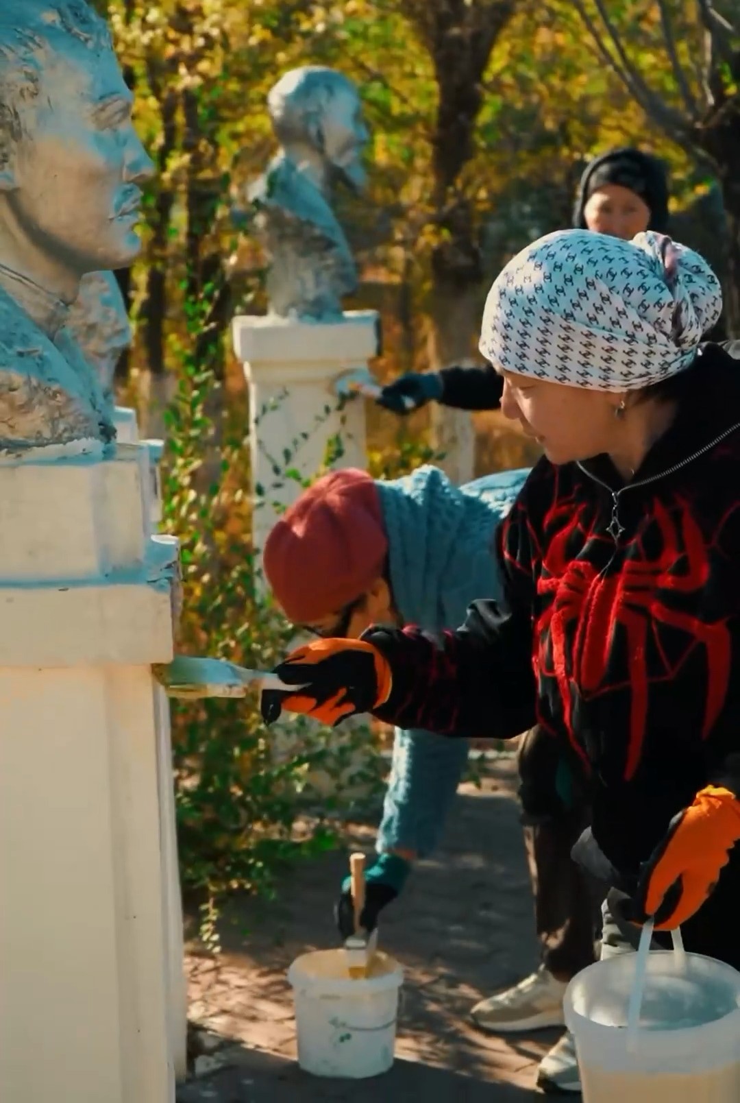 Жасөспірімдер саябақтағы мүсіндердің тұлғаларын бояп, жаңартып жатыр.