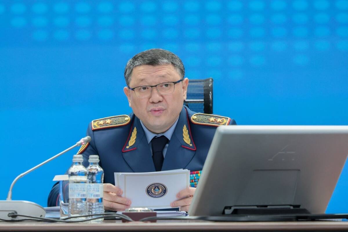 Ішкі істер министрі Ержан Саденов үстел басында құжат ұстап отыр.