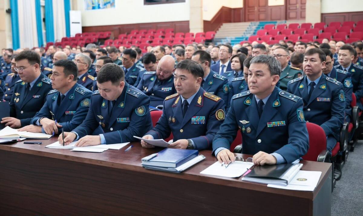 Көк форма киген полиция қызметкерлері жиналыста отыр.