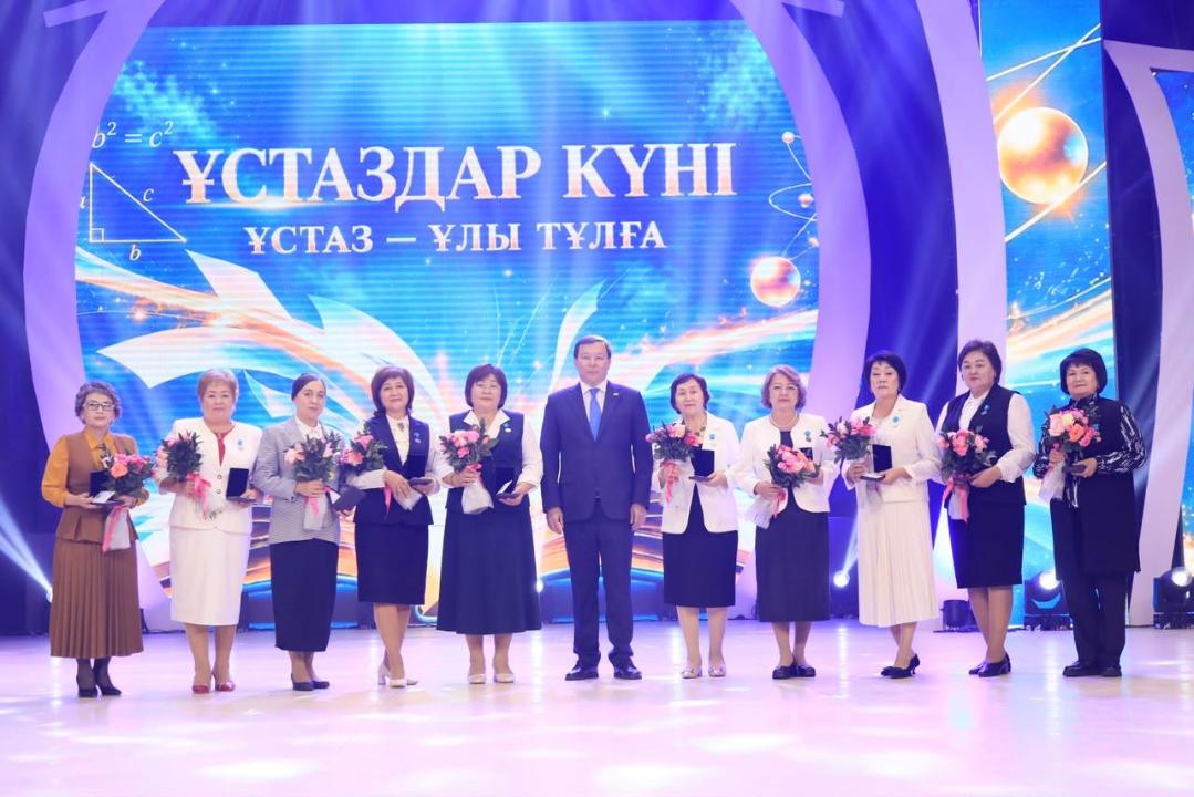 «Ұстаздар күні» мерекесіне арналған салтанатты жиындағы мұғалімдер мен қонақтардың топтық суреті.
