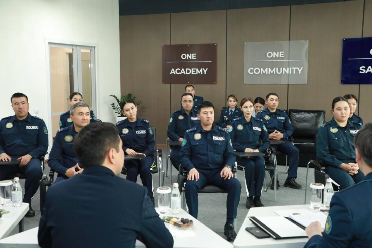 Полиция формасындағы қызметкерлер жиналыста отыр.
