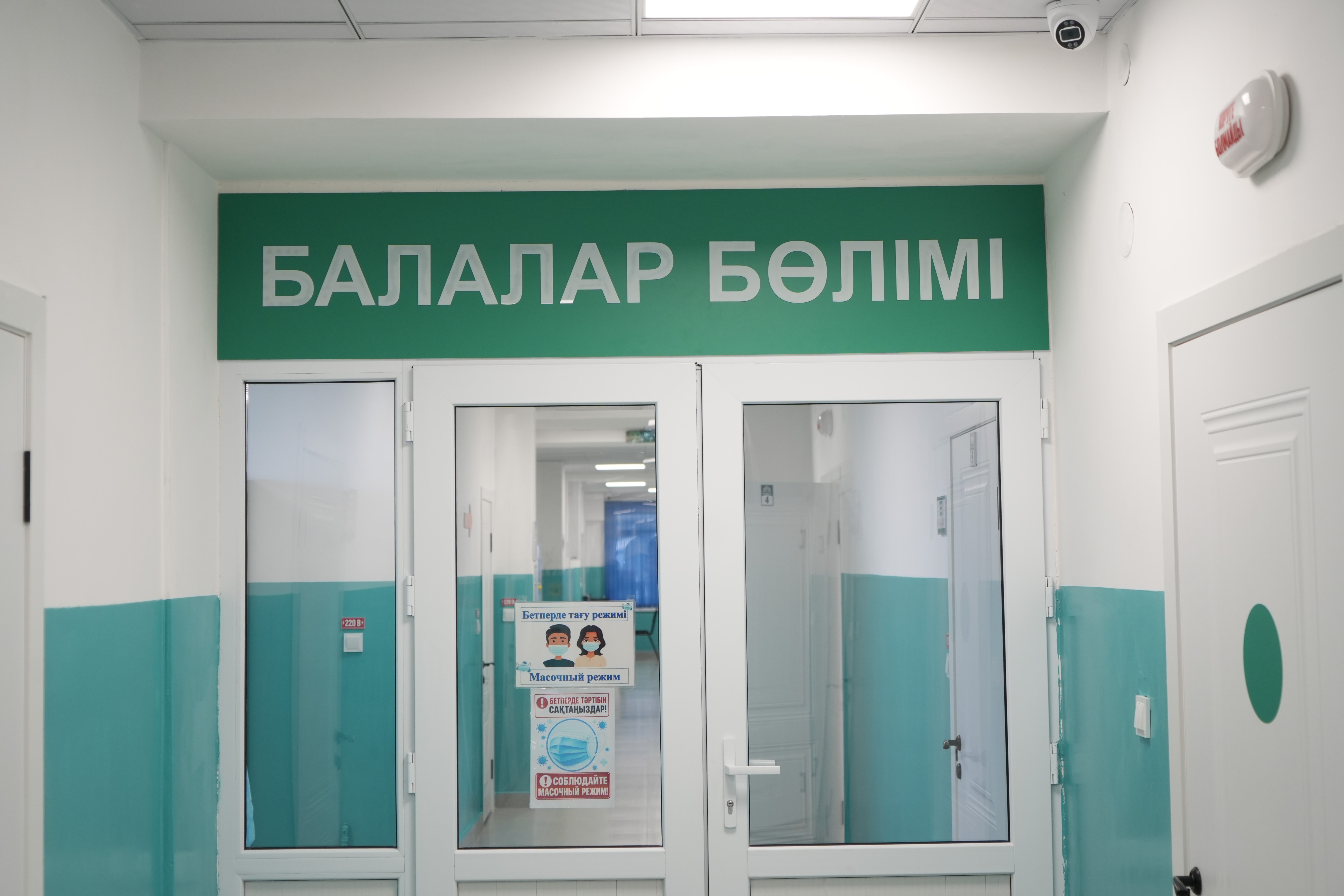 «Балалар бөлімі» деген жазуы бар аурухана дәлізі мен бөлмесінің кіреберісі.