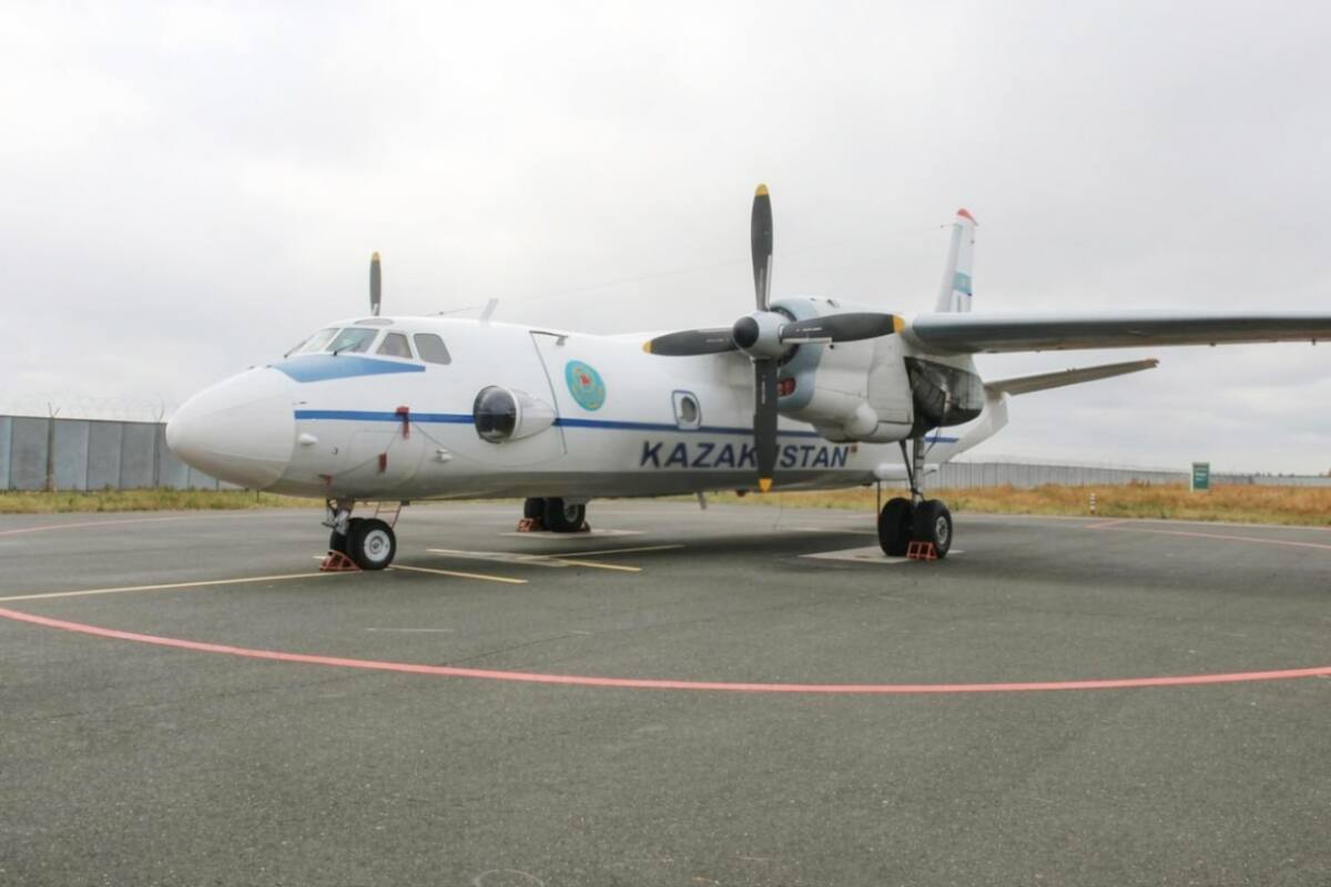 Әуежайда тұрған «Kazakhstan» жазуы бар ақ түсті Ан-26 әскери-тасымал ұшағы.