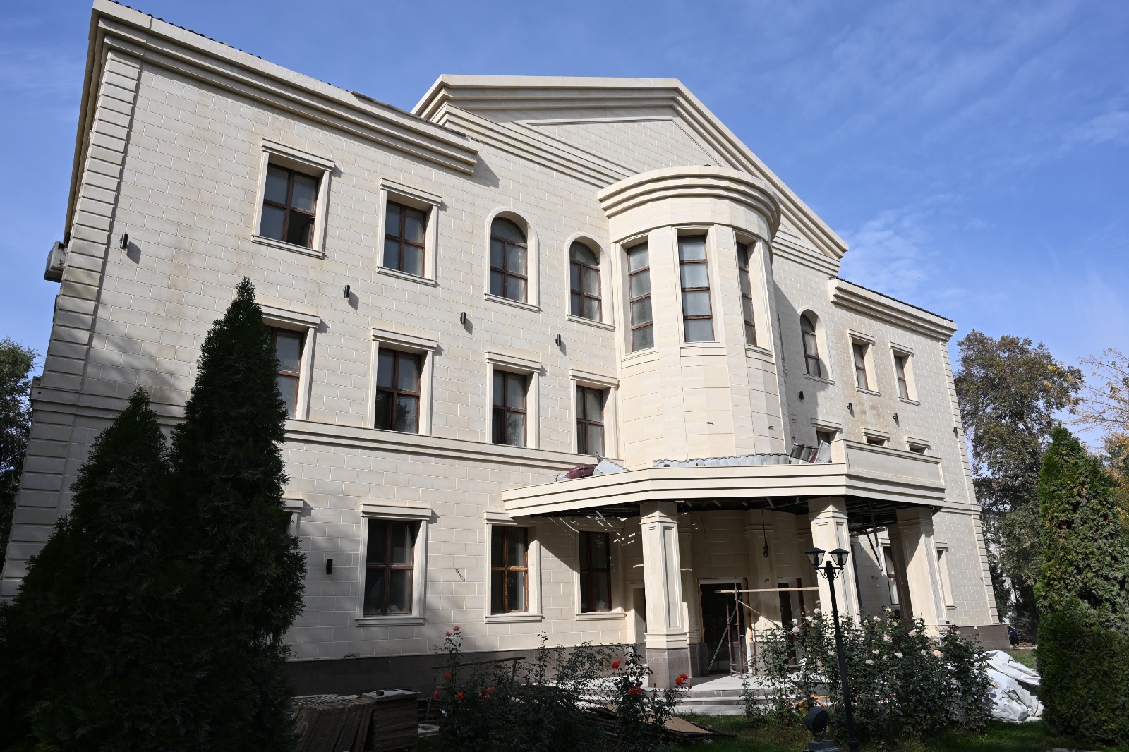 Үш қабатты, ақ тастан салынған классикалық стильдегі зәулім үй.