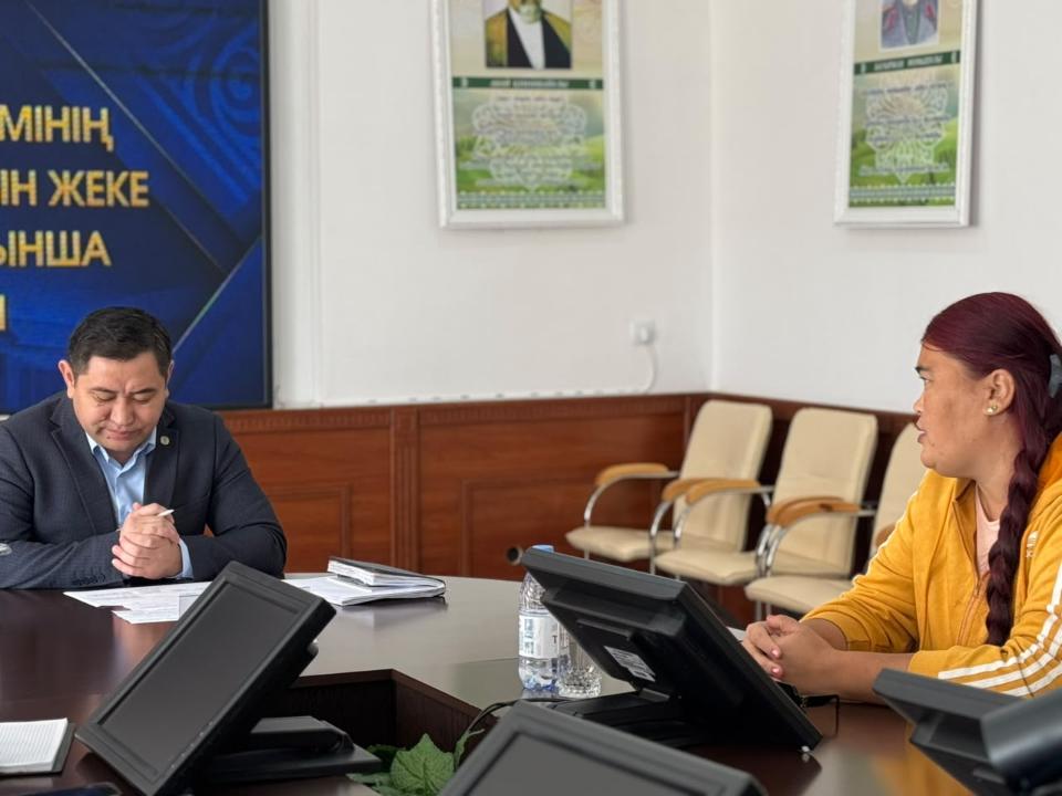 Келіссөз жүргізіп жатқан екі адам: костюм киген ер адам мен сары жейде киген әйел.