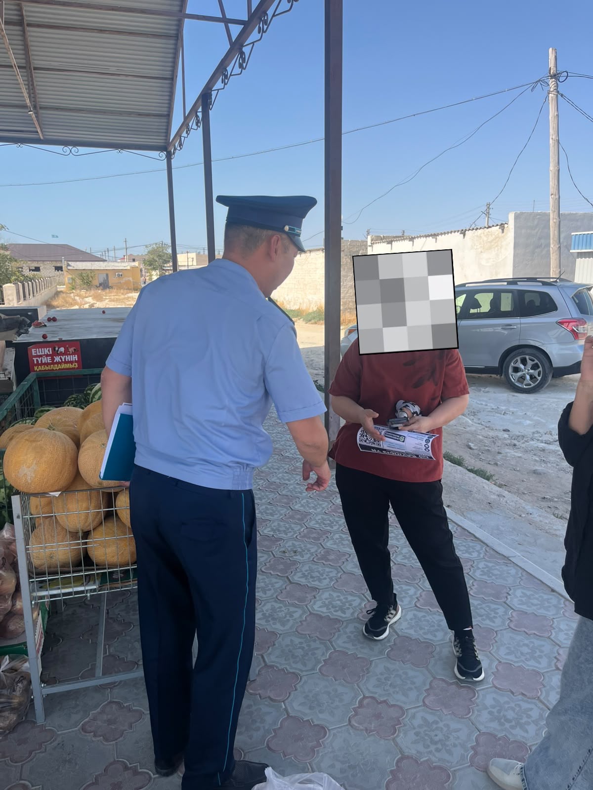 Форма киген полиция қызметкері көшеде тұрған жасөспіріммен сөйлесіп тұр.