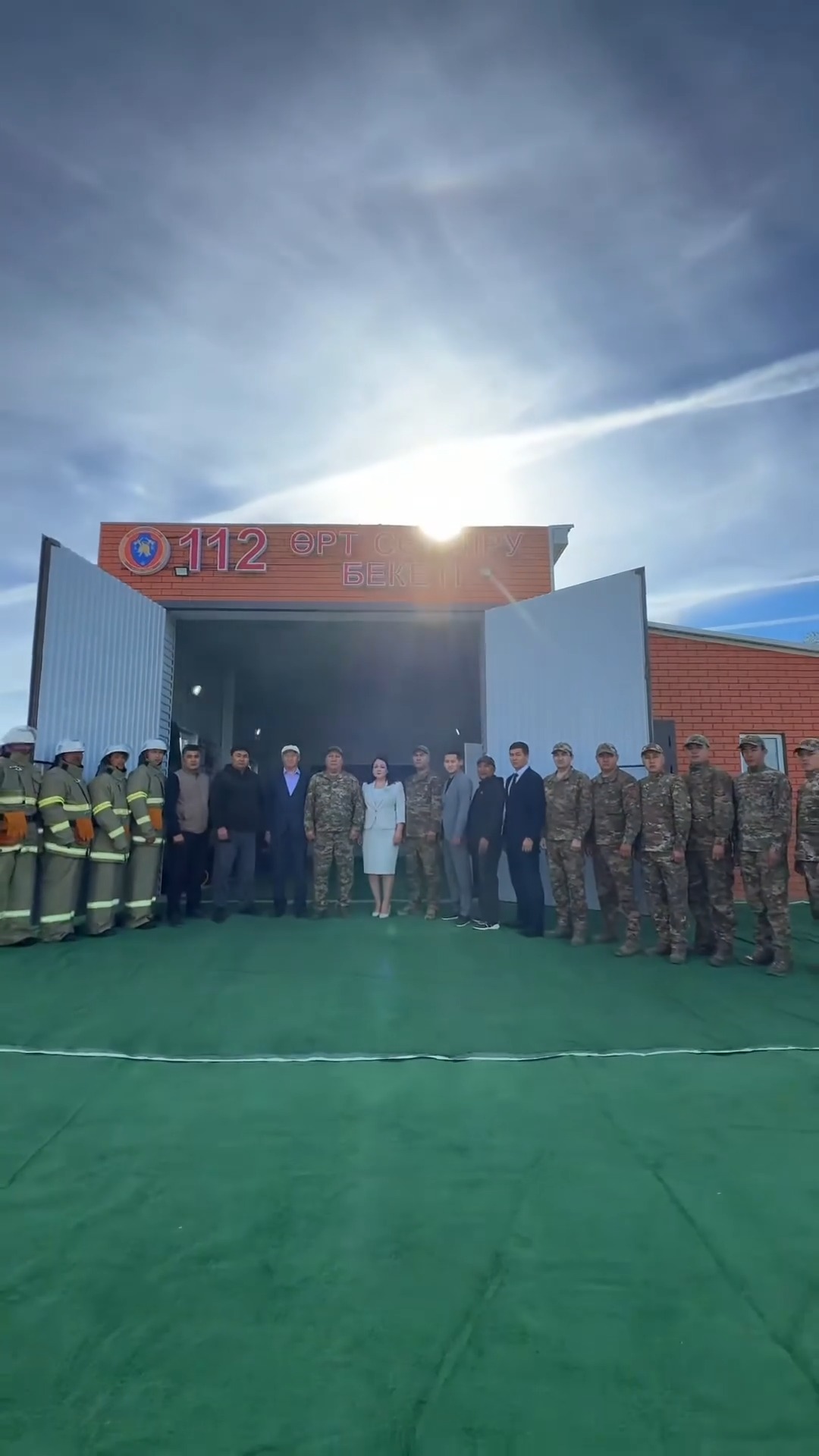 Өрт сөндіру бекетінің алдында тізіліп тұрған өрт сөндірушілер мен әскери қызметшілер тобы.