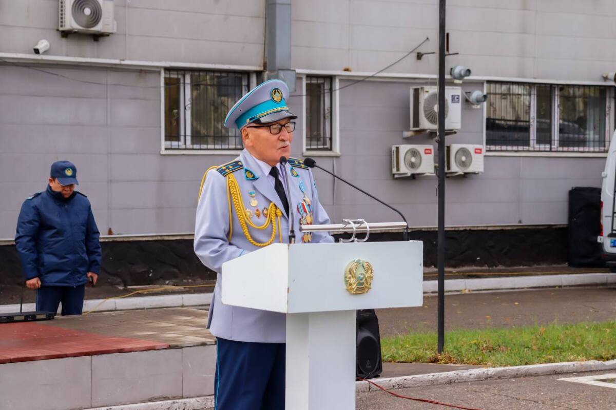 Форма киген офицер трибунада микрофонға сөйлеп тұр.