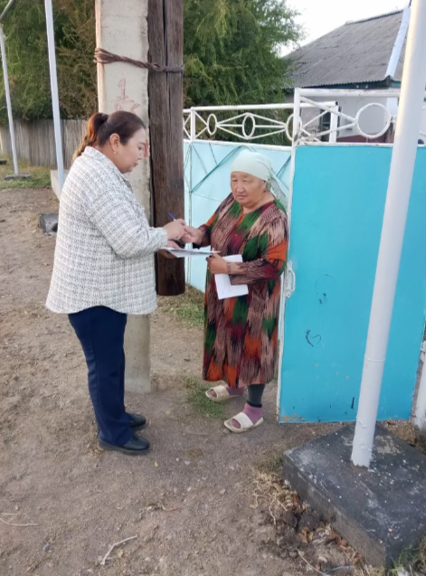 Құжатқа қол қойып жатқан екі әйел.