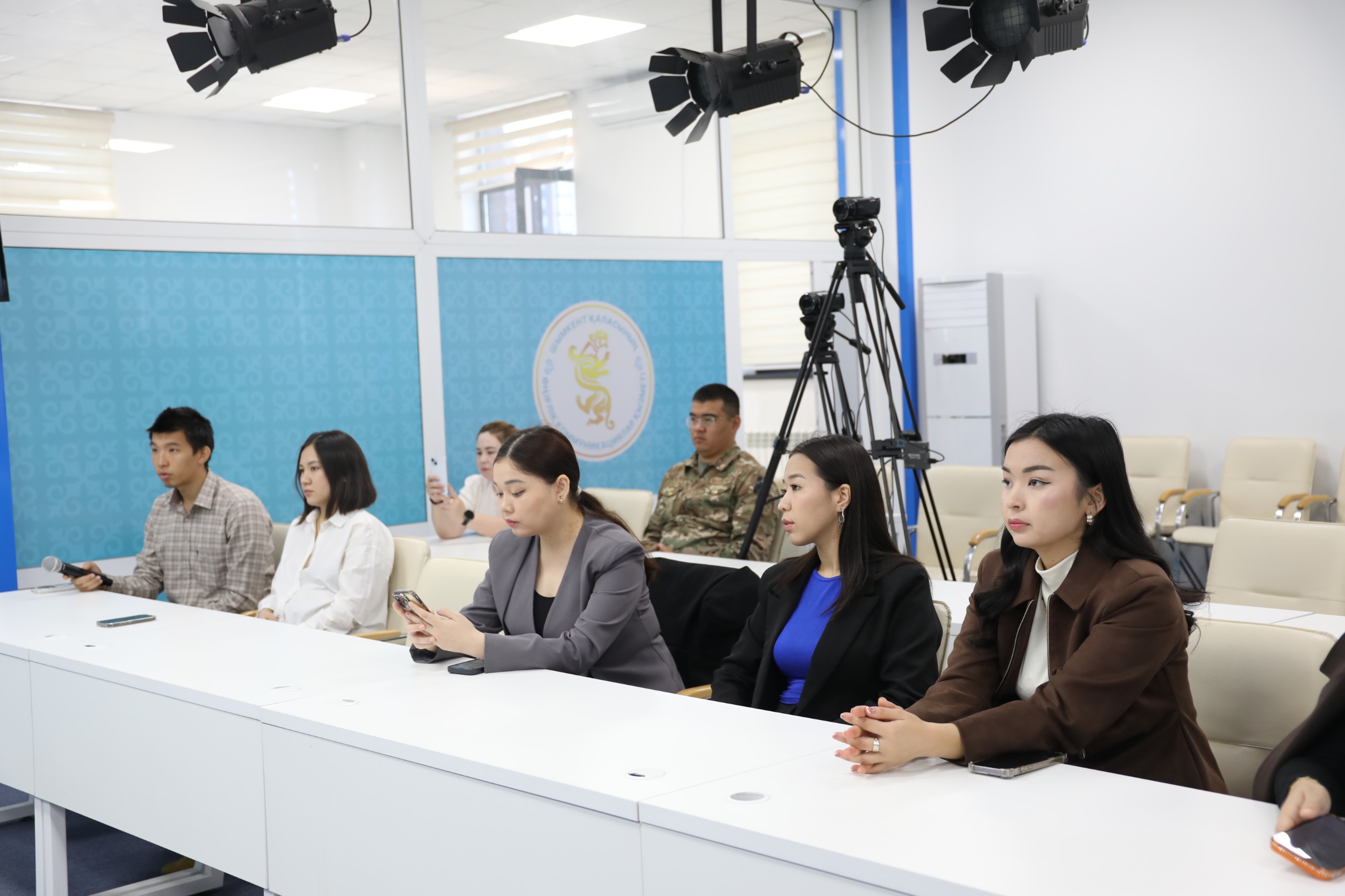 Конференцияда үстел басында отырған қатысушылар.