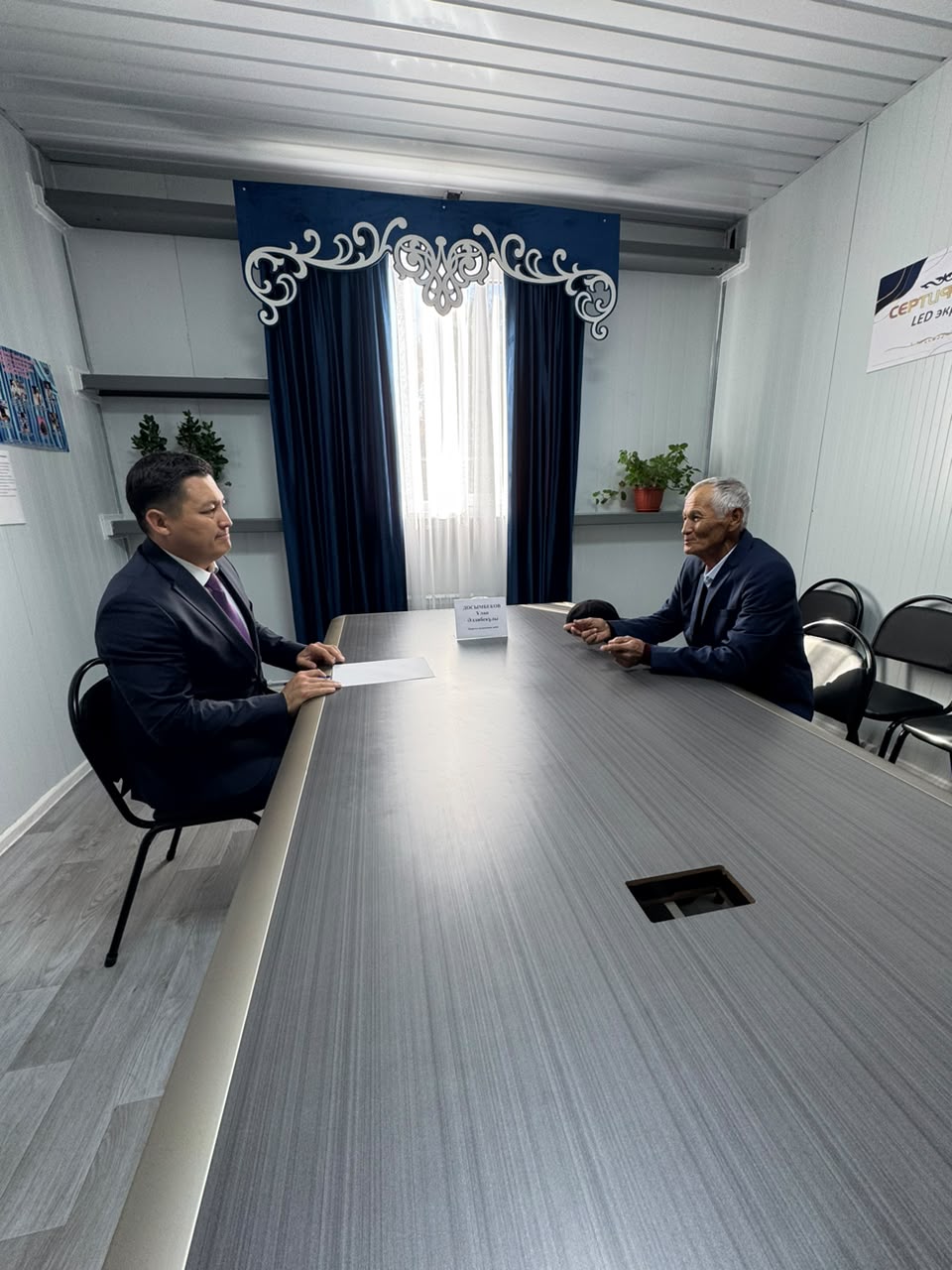 Келіссөз жүргізіп жатқан екі ер адам.