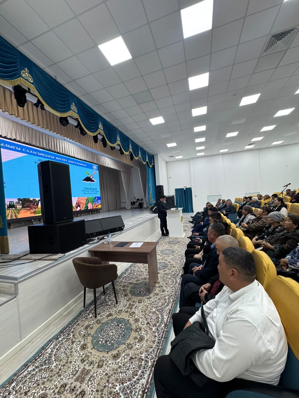 Конференция залындағы презентация және тыңдаушылар.