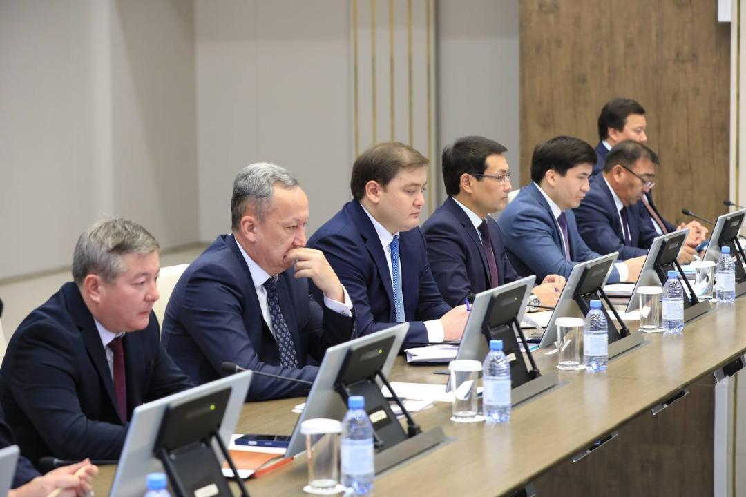 Костюм киген ер адамдардың жиналыста үстел басында отырғаны.