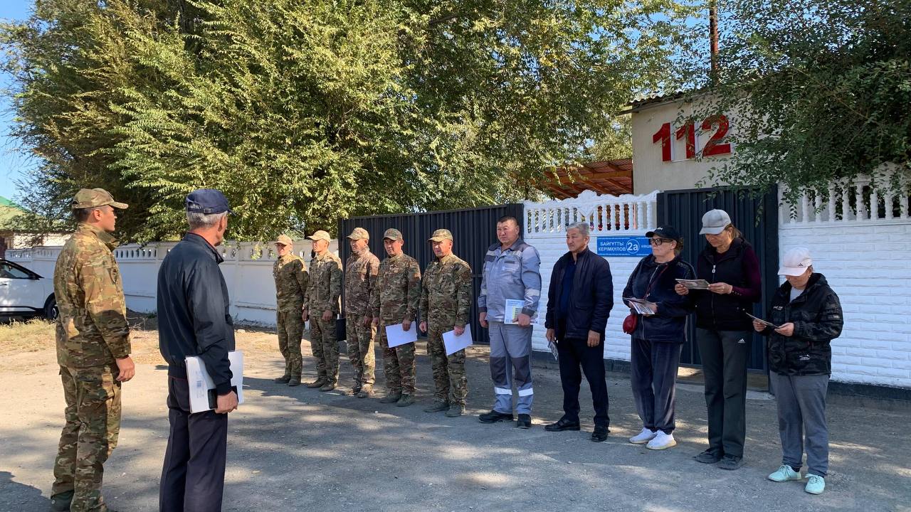 Әскери формадағы сарбаздар мен азаматтық киімдегі адамдардың жиналысы.
