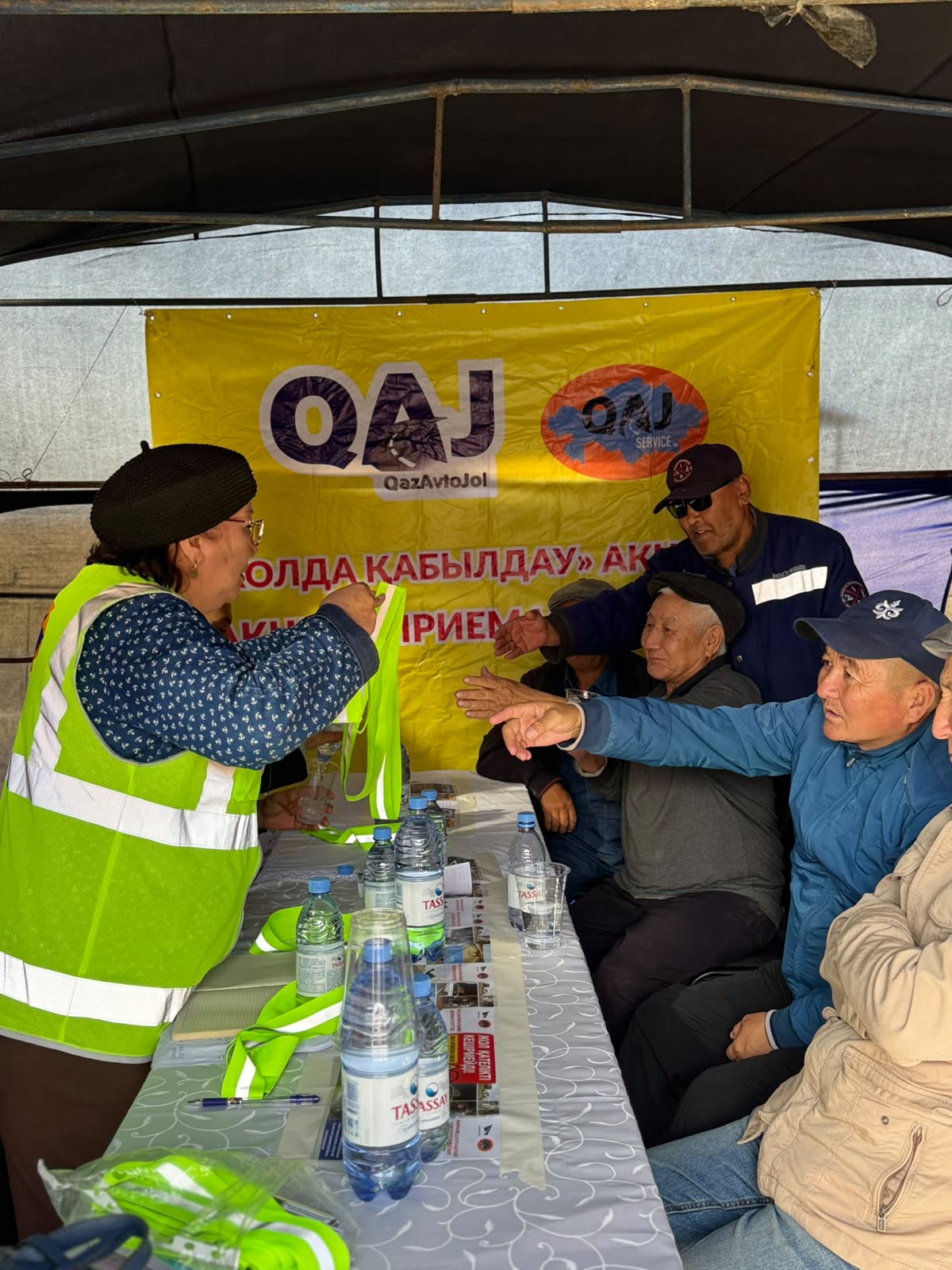 QazAvtoJol өкілінің жүргізушілерге сары рефлекторлы жилеттерді таратуы.
