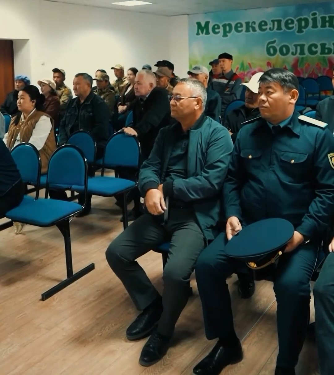 Жиналыста отырған полиция қызметкерлері мен басқа да қатысушылар.